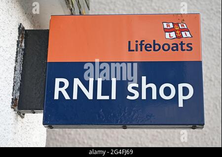 Isoliertes Schild für den RNLI Shop mit verschwommenem weißen Wandhintergrund. Stockfoto