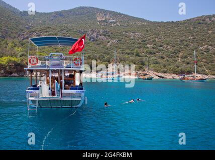 Kalka, Türkei. 2020. Touristen schwimmen im Meer in der Nähe von festgeschmiegten Charterschluchten in einem geschützten Teil der Bucht von Kalkan; auf dem türkischen Medi gelegen Stockfoto