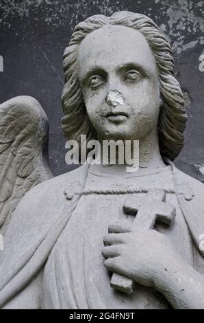 Engel mit Kreuz - beschädigte Statue auf einem Grabstein - alter Prager Friedhof, Tschechien, Europa Stockfoto