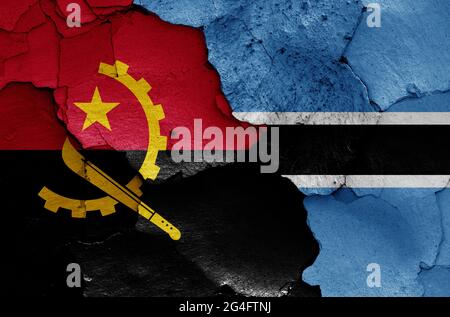 Flaggen von Angola und Botswana auf rissige Wand gemalt Stockfoto