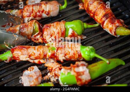 Jalapeno knallt auf das Brennen, grillen. Würzige Paprika, gefüllt mit Frischkäse und in Speck eingewickelt. Draufsicht mit selektivem Fokus. Stockfoto