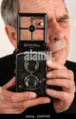 Männlicher Fotograf mit Rolleiflex-Spiegelreflexkamera aus den 1930er Jahren. Standard Rolleiflex 6x6 K2 Doppellinsenreflexkamera aus dem Jahr 1932 Stockfoto