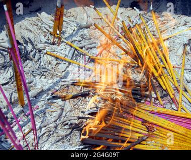 Räucherstäbchen im alten Tempel von Famen, Provinz Shaanxi, China. Räucherstäbchen in Gold und Rosa mit chinesischen Schriftzeichen. Stockfoto
