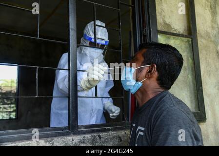 Guwahati, Indien. Juni 2021. Ein Gesundheitsmitarbeiter nimmt eine Abstrichprobe von einer Person, um in einem Testzentrum in Guwahati auf die Covid-19-Coronavirus-Krankheit zu testen. Quelle: David Talukdar/ZUMA Wire/Alamy Live News Stockfoto