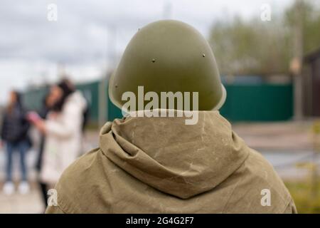 Ein Soldat in einem Helm. Militär von hinten. Militäruniform aus dem Zweiten Weltkrieg. Ein Mann im Regenmantel. Stockfoto