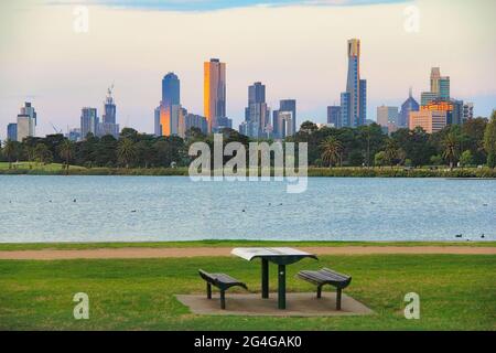 Blick auf den Picknicktisch in einem öffentlichen Park mit dem Hintergrund der Hochhäuser von Melbourne CBD, Australien. Stockfoto