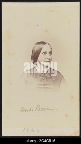Carte-de-Visite von Mary Barker Bowen im Büstensorträt. Ihr Körper steht zur Kamera, aber ihr Kopf ist ein Viertel nach links gedreht und sie schaut von der Kamera. Ihr Haar wird in der Mitte geteilt und am Nacken zu einem Chignon gezogen. Sie trägt ein dunkles Mieder mit einem weißen Kragen und einer ovalen Brosche an ihrem vorderen Hals. Der untere Teil des Bildes wird im populären Stil der Zeit gezielt verblasst.;handschriftlich in Graphit auf dem unteren Rand des Drucks ist der Name "Mrs. Bowen" mit der Aufschrift "1866" unterhalb des Aufdrucks auf der Halterung. Es gibt eine grün-weiße 3-Cent-Cancele Stockfoto