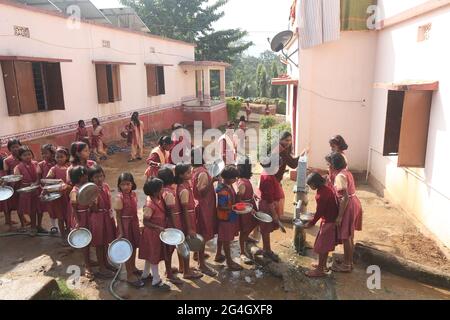 LANJIA SAORA STAMM. Mädchen Studenten einer Stammesschule im Dorf Puttasingh waschen ihre Teller nach dem Essen am Wasserhahn. Puttasingh Dorf in Odisha, in Stockfoto