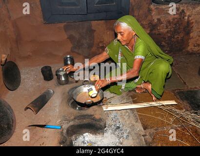 DHANKA TADVI STAMM. Alte Frau macht Tee. Akkalkuwa tehsil aus dem Distrikt Nandurbar in Maharashtra, Indien. Die Tadvi Bhil stammen aus der größeren ethnischen Gruppe von Bhil Stockfoto