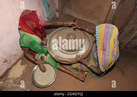 DHANKA TADVI STAMM. Zwei Frauen, die im Dorf Mogarapani - Akkalkuwa tehsil - Nandurbar Dist - Maharashtra an einer traditionellen Maschine schleifen Stockfoto