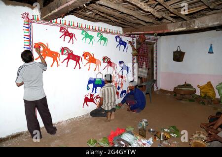 RATHAWA TRIBAL-Künstler zeichnen Pithora-Gemälde auf einer Lehmwand in einem Haus. Pithora Gemälde sind hoch angereichert Volkskunstkultur von Gujarat Stockfoto