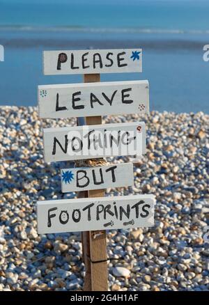 Schild „Please leave nothing but footprints“ am Strand in East Wittering, Chichester, West Sussex, England Stockfoto