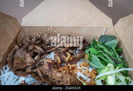 Vietnamesisches Gericht Bun Bo Nam Bo in einer Take-Out-Box - Rindfleisch, Nudeln, Bohnensprossen und Gemüse Stockfoto