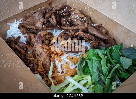 Vietnamesisches Gericht Bun Bo Nam Bo in einer Take-Out-Box - Rindfleisch, Nudeln, Bohnensprossen und Gemüse Stockfoto