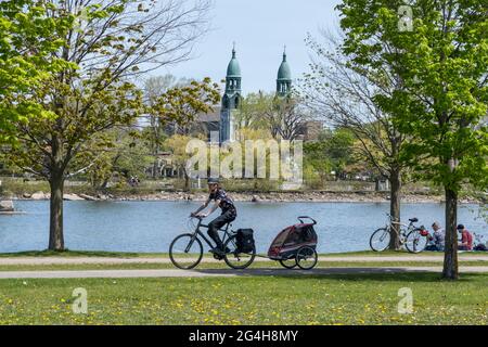 Lachine, CA - 15. Mai 2021: Menschen gehen mit Hund auf dem Radweg des René Lévesque Parks Stockfoto