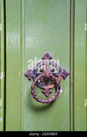 Grün bemalte hölzerne Kirchentür mit rostigen Ringgriff Stockfoto