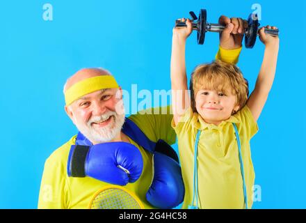 Familiensport. Opa und Sohn trainieren gemeinsam. Kind Junge Hantel heben. Großvater und Kind sportlich. Stockfoto