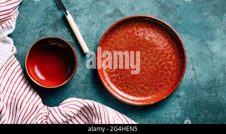 Küche Hintergrund. Rote Keramikplatte auf blauem Hintergrund. Kopierraum Stockfoto