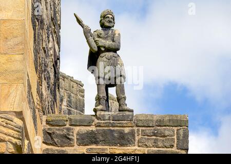 ALNWICK, ENGLAND - 10. JUNI 2021: Statue eines Kriegers auf dem Dach des Schlosses von Alnwick in Northumberland Stockfoto