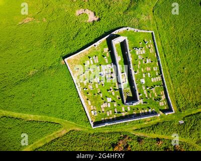 Luftaufnahme von der Drohne der St John’s Church und Kirkyard mit Blick auf das Dorf Gardenstown an der Moray firth Coast in Aberdeenshire, Schottland, Großbritannien Stockfoto