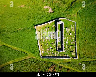 Luftaufnahme von der Drohne der St John’s Church und Kirkyard mit Blick auf das Dorf Gardenstown an der Moray firth Coast in Aberdeenshire, Schottland, Großbritannien Stockfoto