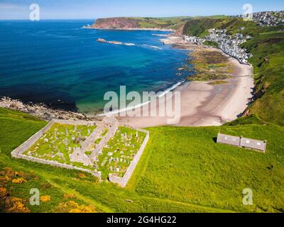 Luftaufnahme von der Drohne der St John’s Church und Kirkyard mit Blick auf das Dorf Gardenstown an der Moray firth Coast in Aberdeenshire, Schottland, Großbritannien Stockfoto