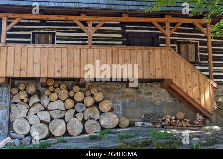 Ein Fachwerkhaus mit einer Veranda, unter der sich Feuerholz befindet Stockfoto