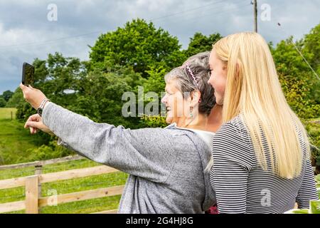 Junge und mittlere Frauen fotografieren auf dem Bauernhof in der Nähe von Hexham Northumberland Selfie Stockfoto