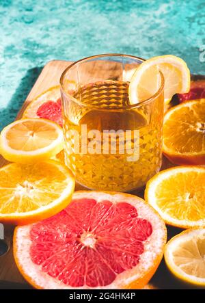 Erfrischender Zitruscocktail im Sommer in einem Glas am Swimmingpool. Orangen, Zitronen, Grapefruits mit kaltsüß-saurem Tonic, Wodka oder aperol Stockfoto