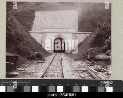 . Ein Eisenbahntunnel auf Java mit einer stationären Lokomotive mit den vorderen zwei Männern. Stockfoto