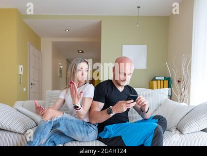 Verärgertes Paar, das während eines Streits auf der Couch sitzt. Stockfoto