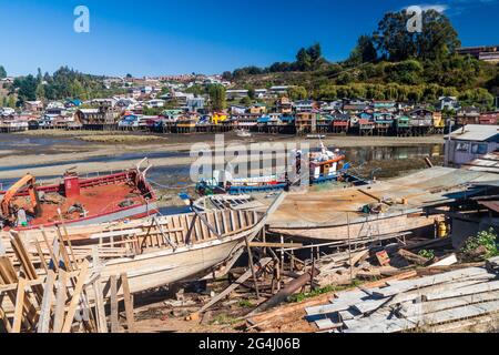 Fischerboote und Palafitos (Stelzenhäuser) bei Ebbe in Castro, Chiloe Island, Chile Stockfoto