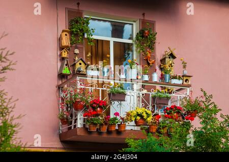Ein malerischer Balkon des Hauses, geschmückt mit Blumen und verschiedenen Objekten. Stockfoto