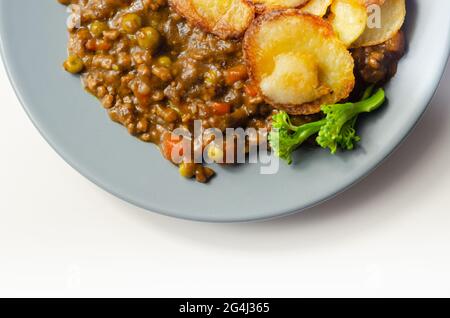 Hackfleisch-Hotpot, zartes britisches Rindfleisch in einer wärmenden Soße mit Karotten und Erbsen, alles gekrönt mit geschnittenen Bratkartoffeln, klassische Mahlzeit Stockfoto