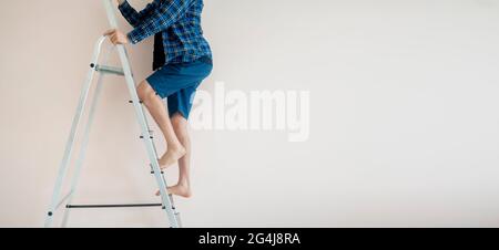 Nahaufnahme Arbeiter Füße auf der Leiter klettern nach oben gegen die Wand mit Kopierraum Stockfoto