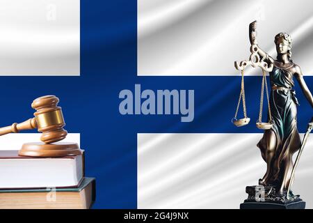 Recht und Gerechtigkeit in Finnland. Statue von themis und der Gavel des Richters vor dem Hintergrund der Flagge Finnlands. Recht und Gerechtigkeit Konzept. Stockfoto