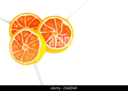 Orange gewürzte Süßigkeiten auf einem Stock. Orange Bonbons auf weißem Hintergrund. Stockfoto