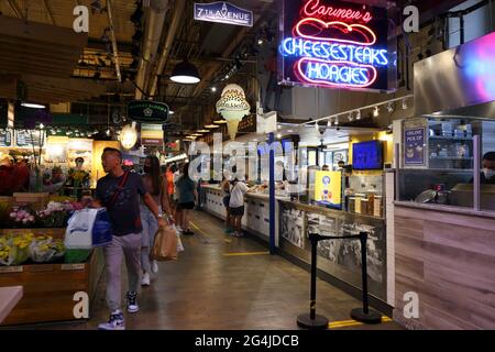 Menschen, die Taschen mit Leckereien vom Reading Terminal Market, Philadelphia, PA, tragen. Stockfoto