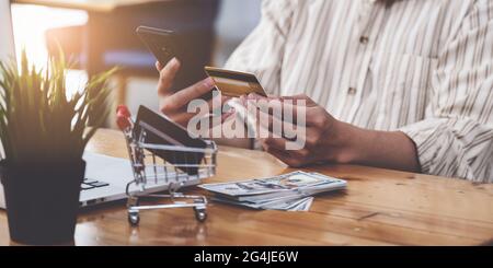 Ein Mann mit Kreditkarte und Eingabe der Kreditkartennummer Smartphone für Online-Shopping und Zahlung macht einen Kauf im Internet. Stockfoto