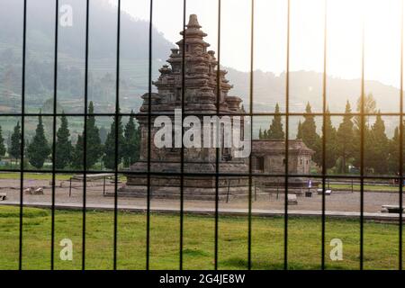 Arjuna- und Semar-Tempel hinter einem schwarzen Metalltor Stockfoto