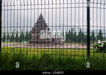 Arjuna- und Semar-Tempel hinter einem schwarzen Metalltor Stockfoto