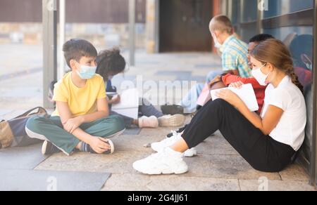 Grundschüler in Masken reden draußen Stockfoto
