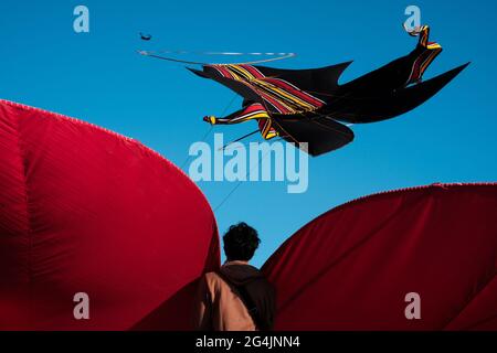 Balinesischer Junge mit EINEM riesigen Drachen gegen EINEN klaren blauen Himmel Stockfoto