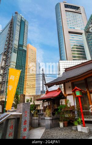 Tradition und Moderne in Japan. Blick auf Shimbashi-Shiodome moderne Hochhäuser hinter dem roten Tor der Hibiya Schrein in der Innenstadt Stockfoto