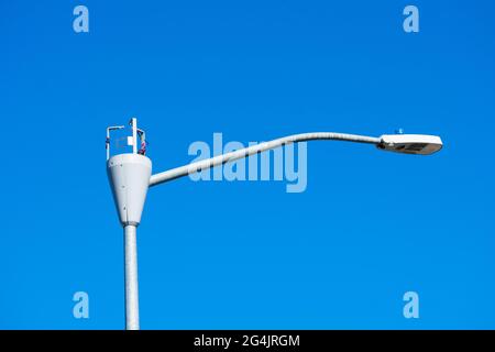 Die Installation einer Kleinzellenantenne an einem Lampenpfosten wird gerade durchgeführt. Die Schutzverkleidung der Antenne wurde entfernt, Teile sind sichtbar. Stockfoto