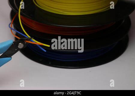 Für die 3D-Druckmaschine sind diese Filamente oder thermoplastischen Spulen erforderlich. Drei Rollen horizontale Ansicht mit Filamenten im Schneider gehalten Stockfoto