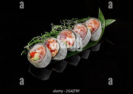 Sushi-Rollen mit Thunfisch, Lachs, Krabben, Tobiko und Avocado in den Mamenori Stockfoto