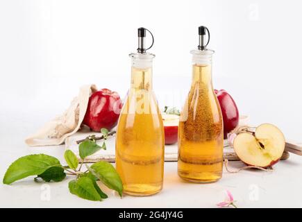 Apfelessig und frische Äpfel auf hellem Hintergrund. Gesunde Bio-Lebensmittel. Stockfoto