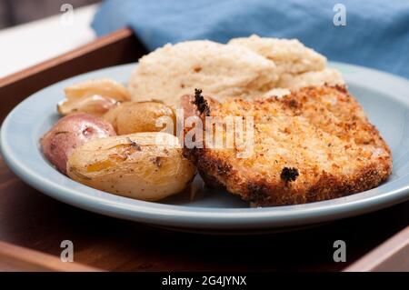 Nahaufnahme eines panierten Schweinekoteletts und Kartoffeln mit püriertem Blumenkohlpüree Stockfoto