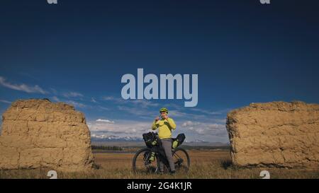 Der Mann reist auf gemischtem Terrain mit Bikepacking. Die Reise des Reisenden mit Fahrradtaschen. Sport Tourismus Bikepacking. Stockfoto